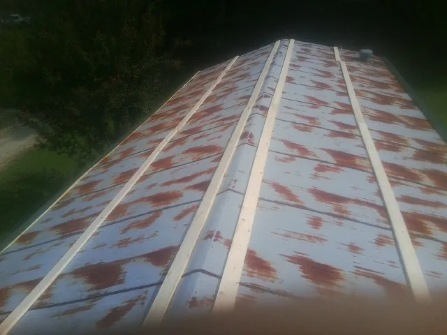 Rusted metal roof panels with new wood purlins before replacement — Storm Damage Roof Repair in Pitcher by Roofing Brothers