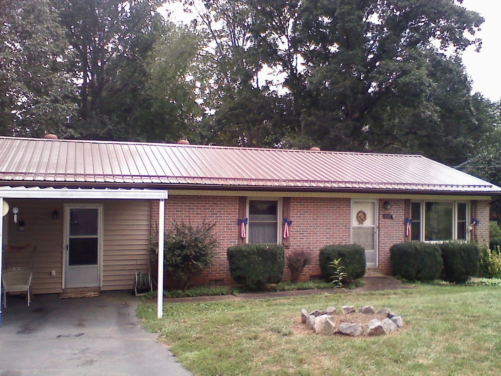 Bronze metal roof and carport on a brick ranch home — Roof Repair work by our crew in Pitcher